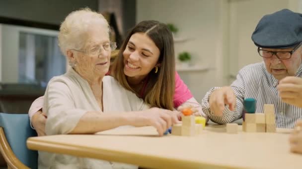 Βίντεο ενός τρυφερού φροντιστή χαμογελώντας και βοηθώντας μια ηλικιωμένη γυναίκα σε μια γηριατρική - Πλάνα, βίντεο