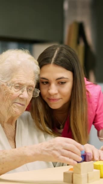 Video van een verpleegster adviseert een oude vrouw om een vaardigheidsspel op te lossen - Video