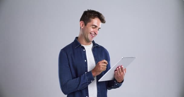 Business, man and tablet in studio with happy, face and confidence for marketing career at work. Entrepreneur, person and portrait with smile for typing or scroll on touchscreen and gray background. - Footage, Video