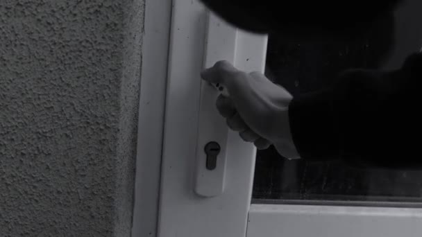 Een man breekt de deur in of trekt sterk aan de deurklink. De dief is een dief. Concept van diefstal en geweld. Hoge kwaliteit 4k beeldmateriaal - Video