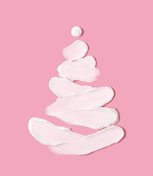 El concepto de un árbol de Navidad en forma de trazos cosméticos sobre un fondo rosa. Fondo de Navidad. - Foto, imagen