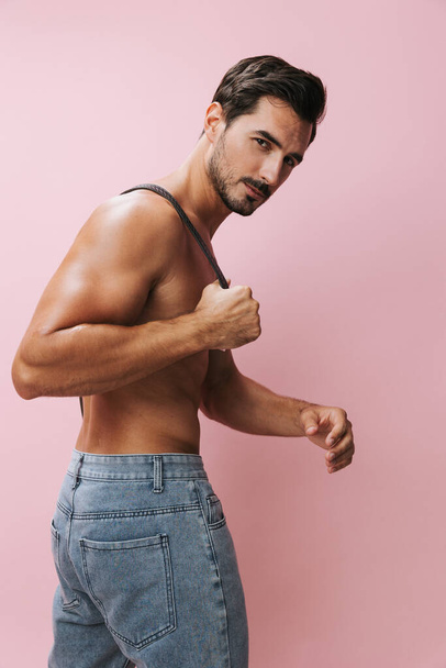mężczyzna tułów silny moda pasek muskularne piękno ciało dopasować nagi tło model bez koszulki fitness biceps jeansy kulturysta styl życia sport różowy wakacje mięśnie sexy - Zdjęcie, obraz