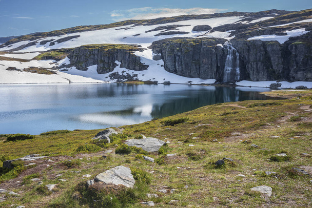 Flotane vesiputous Flotvatnet lähellä Aurland, Norja, pitkin luonnonkaunis Aurlandsfjellet reitti, on dramaattinen vesiputous, joka törmää vuori järvi, keskuudessa lumi tasangot ja huiput. - Valokuva, kuva