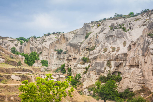 Skalnatá krajina v Kappadokii, Turecko. Cestujte do Cappadocie. Neobvyklá polopouštní pohoří. Úžasná skalnatá letní krajina s jeskyněmi v Cappadocia Goreme - Fotografie, Obrázek