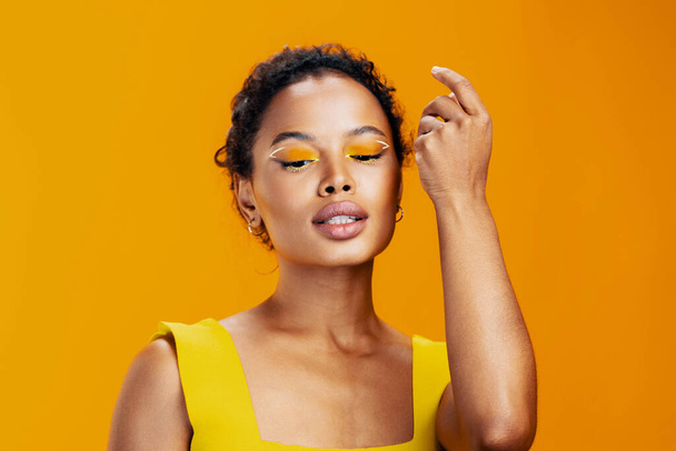 Mujer cosmetología africano moda sonrisa cosmética amarillo piel maquillaje cara espacio belleza estudio colorido hermoso estilo creativo retrato étnico negro modelo rosa copia - Foto, imagen