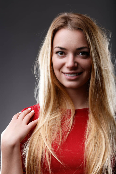 Ojos brillantes y sonriente, la mujer irradia positividad en su traje rojo vibrante - Foto, Imagen