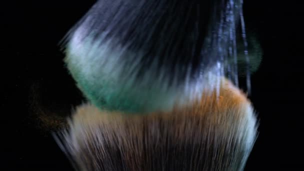 Macro dettaglio di spazzole cosmetiche che si scontrano con arancio volante e polvere verde in super rallentamento - Filmati, video