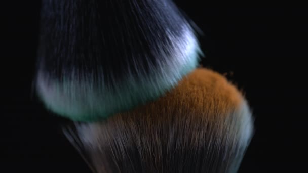 Makro yksityiskohtaisesti kosmeettisia harjat ristiriidassa keskenään super hidastettuna 1000 fps oranssi ja vihreä jauhe lentävät ilmassa - Materiaali, video