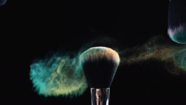 Make-up borstels aanraken met cosmetische deeltjes in Super Slow Motion op donkere achtergrond - Video