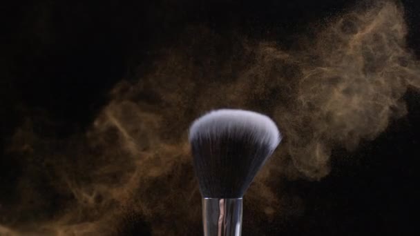 Detailaufnahme in Makro aus orangefarbenen Makeup-Pinseln auf dunklem Hintergrund mit kosmetischen Partikeln in Super-Zeitlupe - Filmmaterial, Video