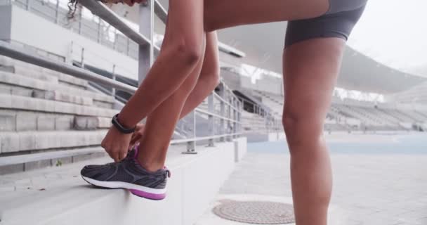 Schoenen, veters en vrouwelijke atleet op de rails met vertrouwen en fitness in de sport met gezondheid wellness. Runner, sterk lichaam en klaar voor de sprint uitdaging met trots en oefening inzet in het stadion. - Video