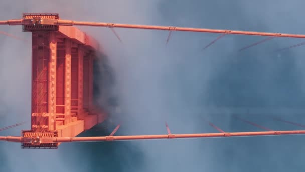 Крупним планом вид на дорогу з трафіком в містичному тумані. Драматичні сльозогінні помаранчеві хмари кружляють на червоній вежі мосту Золоті ворота на заході сонця. Позашляховик автомобілів, що керує мостом Золоті Ворота Сан-Франциско - Кадри, відео