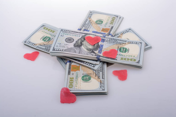 Czerwone serca i wiązka banknotów w dolarach amerykańskich - Zdjęcie, obraz