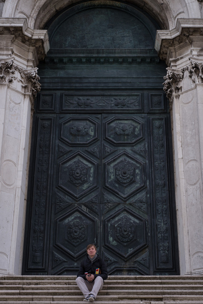 A young boy on the stairs in front of the temple of Venice - Foto, immagini