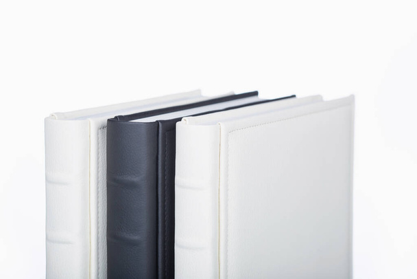 photo books with cover of genuine leather. Wedding photobooks in white and black leather binding. Family album. Services of a professional photographer and designer. Stylish books on white blackground - Photo, Image