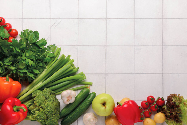 Fresh vegetables and fruits on white tile background - Photo, Image