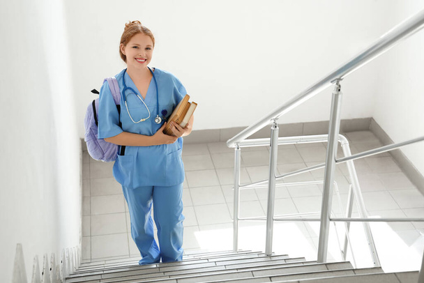 Medizinstudentin mit Büchern auf der Treppe der Universität - Foto, Bild