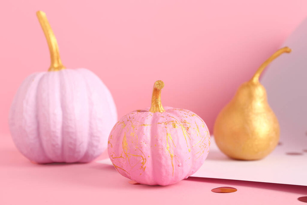 Different painted pumpkins with golden pear on colorful background - Photo, Image