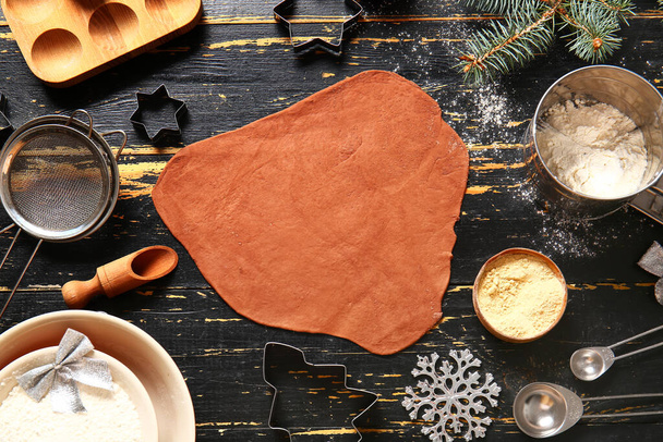 Massa fresca e ingredientes para biscoitos de gengibre de Natal em fundo de madeira preta - Foto, Imagem