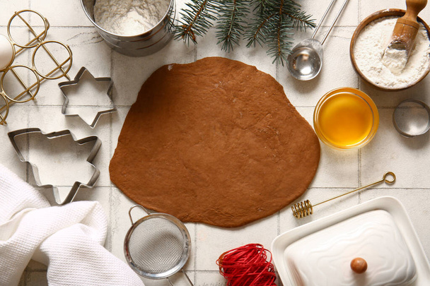 Pâte fraîche et ingrédients pour biscuits au pain d'épice de Noël sur fond de carreaux blancs - Photo, image