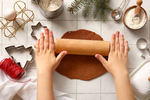 Beyaz fayanslı Noel kurabiyeleri için zencefilli ekmek yapan bir kadın. - Fotoğraf, Görsel