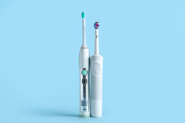 Cepillos de dientes eléctricos sobre fondo azul. - Foto, imagen