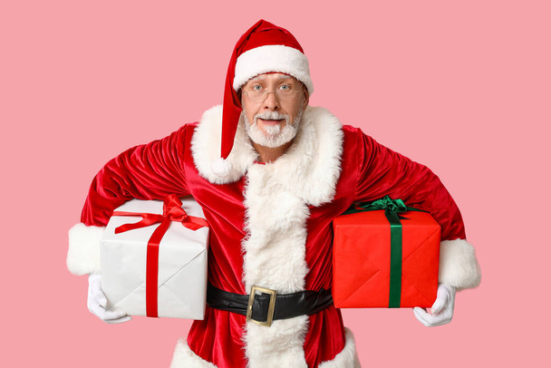 Cool Santa Claus with gift boxes on pink background - Photo, Image