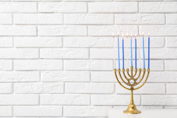 Minorca con candele accese sul tavolo bianco in soggiorno, primo piano. Festa di Hanukkah - Foto, immagini