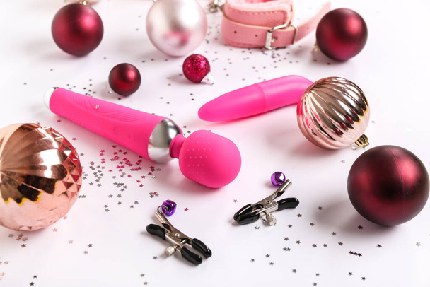 Composizione con diversi giocattoli sessuali e decorazioni natalizie su sfondo bianco - Foto, immagini