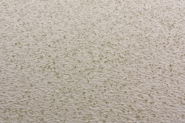 Wateroppervlak met zwaar regent druppels - Foto, afbeelding