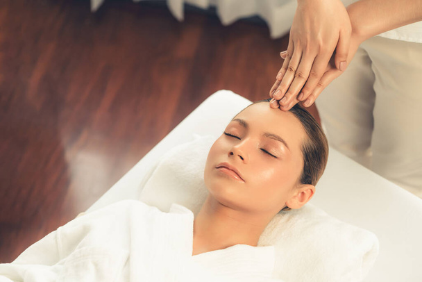 Kavkazská žena si užívá relaxační antistresové masáže hlavy a hýčkání pleti kosmetické rekreace v denním lázeňském moderním lehkém prostředí v luxusním resortu nebo hotelovém lázeňském salonu. Tichý - Fotografie, Obrázek