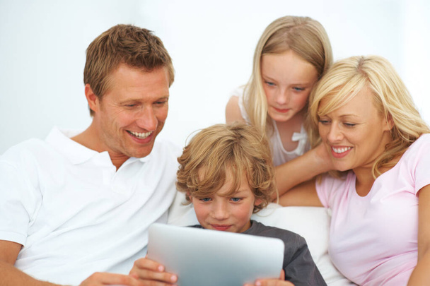 Мати, батько і діти посміхаються з планшетом для навчання, відеоігор або читання історії електронних книг на додатку в сімейному домі. Мама, тато і діти дивляться мультфільм, транслюють цифрові мультимедіа або підписку. - Фото, зображення