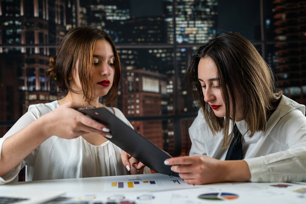 two young pretty women working on financial report at office. Concept - Fotoğraf, Görsel