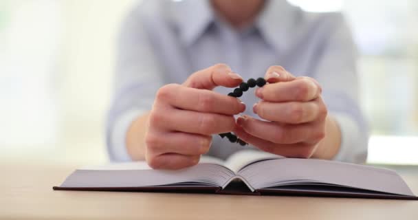 Estudante feminino dedilhado pulseira escura feita de materiais naturais informações de leitura no livro para se preparar para exames. Acalmar-se de preocupações com a ajuda da coisa favorita - Filmagem, Vídeo