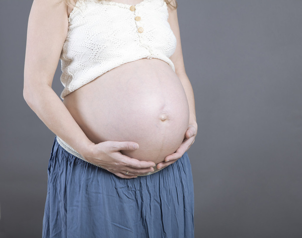 Mujer sosteniendo su baby bump
 - Foto, imagen
