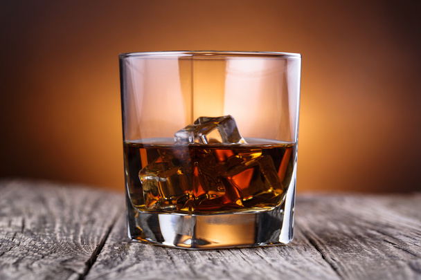 Bardak viski ve buz üzerinde ahşap bir masa. - Fotoğraf, Görsel