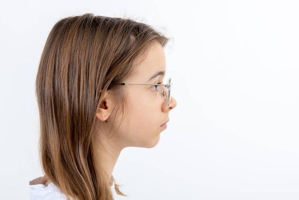 Seitenansicht Porträt eines kaukasischen Teenagers mit Brille im weißen T-Shirt, isoliert auf weißem Studiohintergrund, Kopierraum, Banner. - Foto, Bild