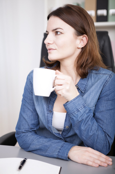 Observant young businesswoman drinking coffee - Photo, Image