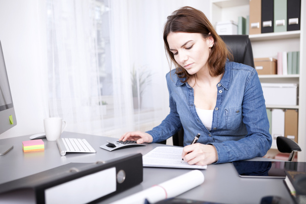 Hardworking businesswoman sitting writing a report - Zdjęcie, obraz