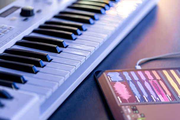 Musical billentyűk és tabletta az asztalon, zenei alkalmazás digitális tabletta, zenei felvétel. - Fotó, kép