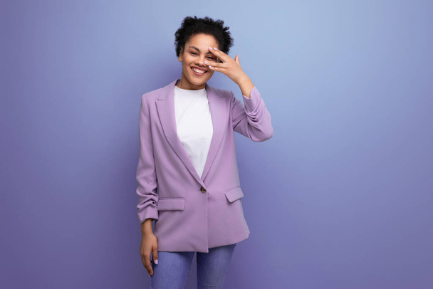 jong succesvol latino brunette leider vrouw gekleed in jas op studio achtergrond met kopieerruimte. - Foto, afbeelding