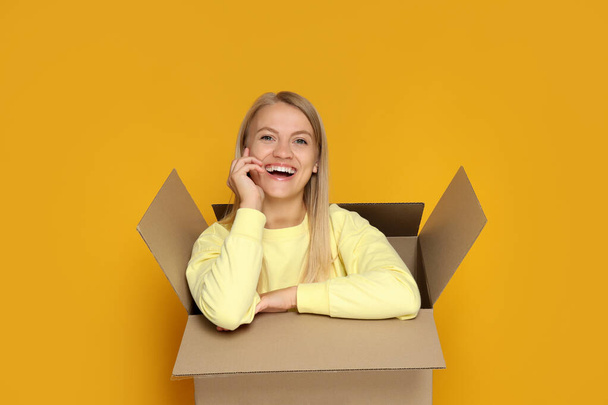 Une jeune fille est assise dans une boîte en carton - Photo, image