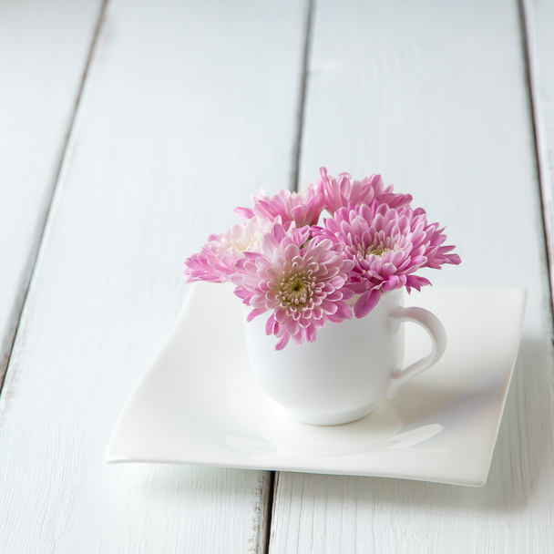 Cup full of pink  mum flowers on  old wooden table. - Foto, immagini