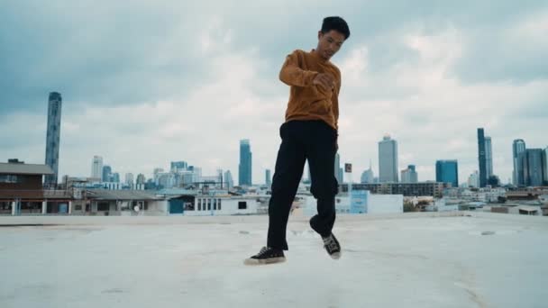 Spectacle de danse B-boy par un danseur de rue sur le toit avec gratte-ciel, vue sur la ville. Attrayant hipster asiatique montrer pas énergique. Break Dancer pratique la danse de rue. Sport de plein air 2024. hiphop. - Séquence, vidéo