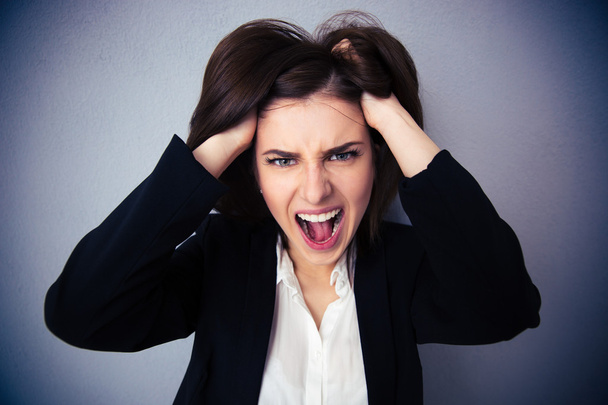 Femme d'affaires en colère criant sur fond gris
 - Photo, image