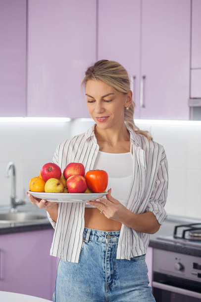 Organic food. Millennial woman is preparing food in kitchen. Diet and healthy eating concept. - Photo, Image
