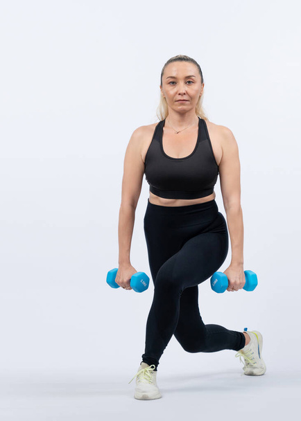 全身の長さショットアクティブでスポーティなシニア女性は,隔離された背景での体重トレーニングのトレーニング中にダンベルを持ち上げます. 年金受給者のための健康的なアクティブな体格とボディケアライフスタイル. クロート - 写真・画像