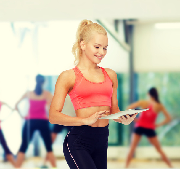 smiling sporty woman with tablet pc computer - Photo, Image