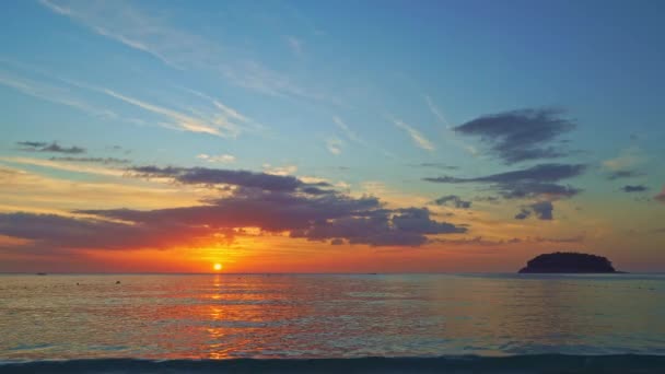 Krajobrazy kolorowe chmury na niebie nad wyspą w godzinach wieczornych.Słońce na kolorowym niebie schodzi za wyspą Pu na plaży Kata Phuket - Materiał filmowy, wideo
