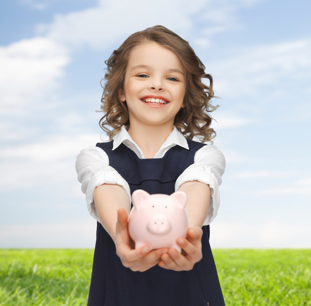 happy girl holding piggy bank on palms - Foto, imagen